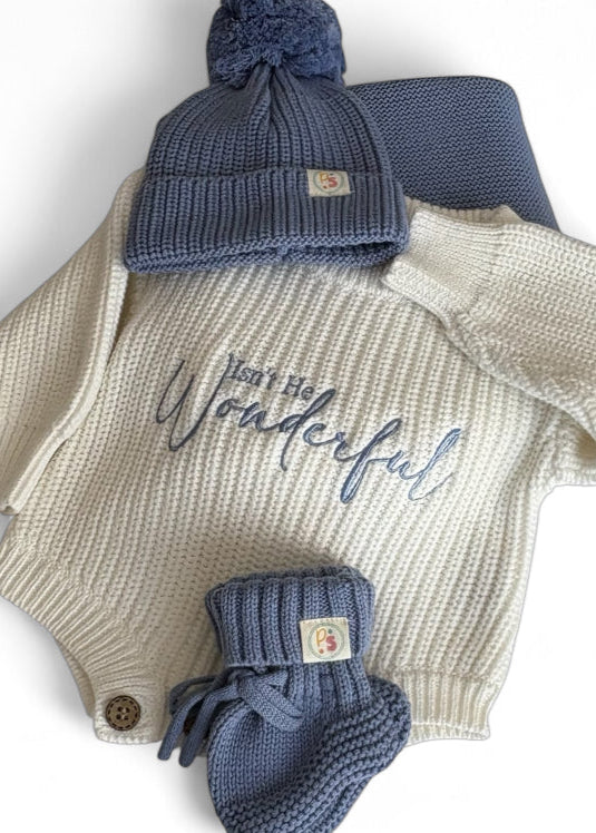 Baby outfit set with sweater, hat, and booties on a white background