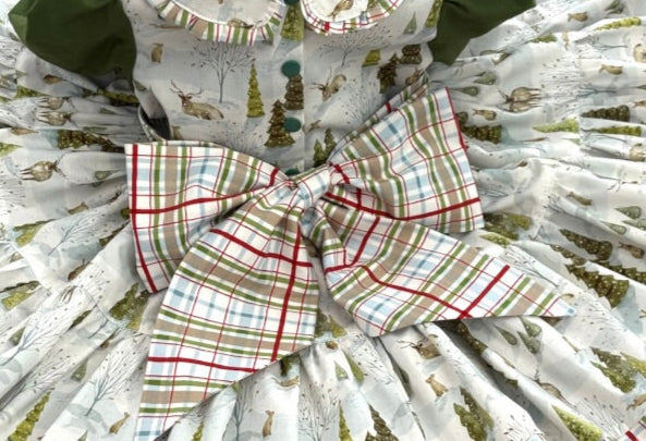 Close up of back view or less featuring oversized plaid bow