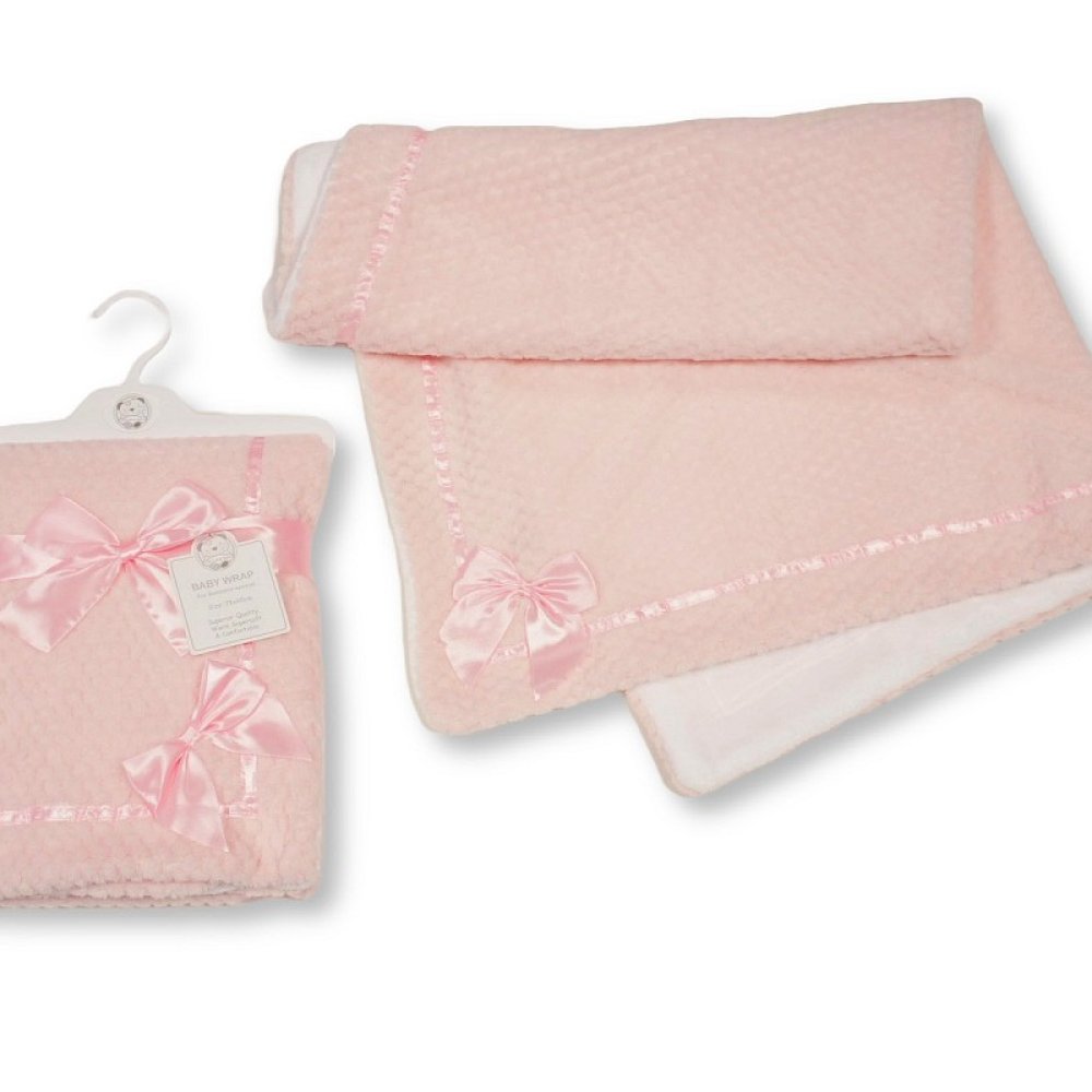 A light pink baby blanket with a textured waffle pattern, delicate pink trim, and a matching satin bow, shown both folded on a hanger and unfolded on a white background.