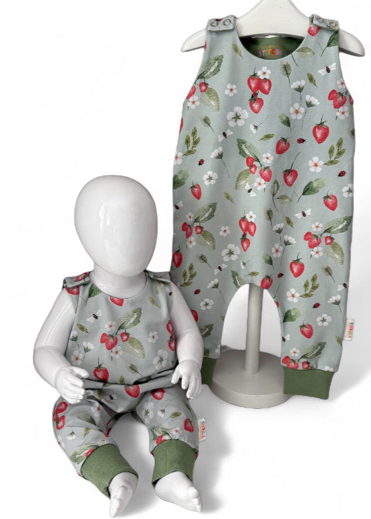 Children's strawberry print romper with floral patterns on a pale green background