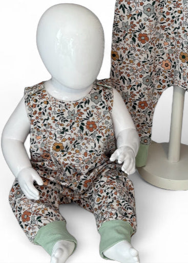 Floral-patterned children's overalls on a mannequin against a white background