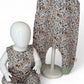 Floral-patterned children's overalls on a mannequin against a white background