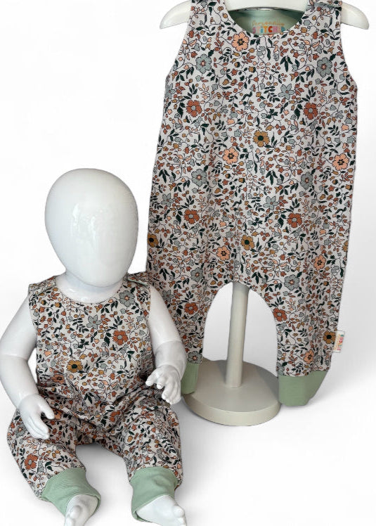 Floral-patterned children's overalls on a mannequin against a white background