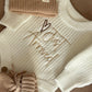 Newborn Coming Home Outfit in Soft Knit Fabric – Gender-neutral knit romper with matching hat, booties, and blanket in beige and cream tones.