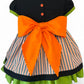 Back view of girls Halloween party dress – features orange buttons, a large bow, and striped skirt with layered green underskirt.