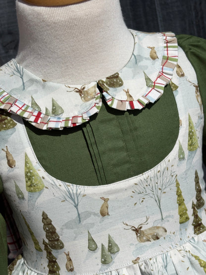 Close up of Peter Pan collar with plaid trim and pin tucks in hunter green solid fabric