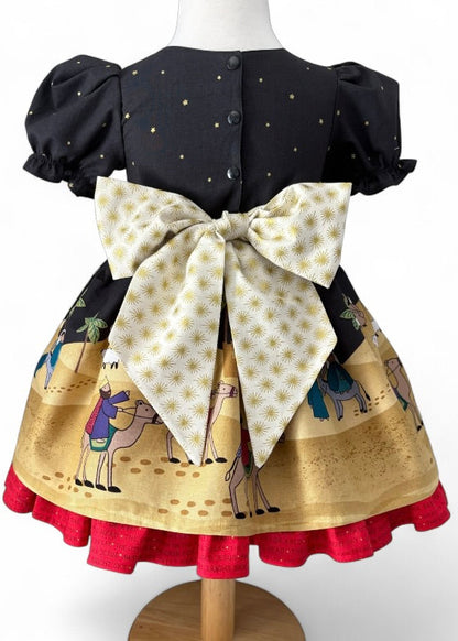 Handmade children’s Christmas dress in Lewis & Irene Away in a Manger nativity print with gold star bow, sizes 12 months to 6 years