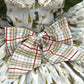 Close up of back view or less featuring oversized plaid bow