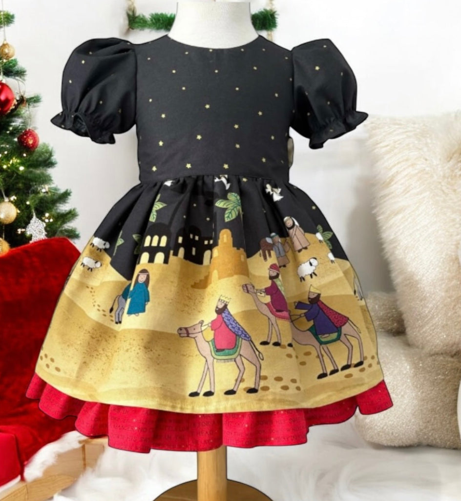 Children's dress with festive design on a mannequin against a Christmas-themed background