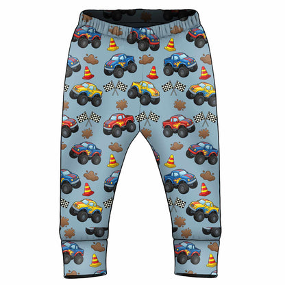 Children's pants with monster truck pattern on a light blue background