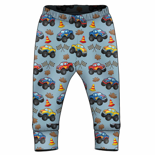 Children's pants with monster truck pattern on a light blue background