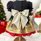 Christmas-themed dress on a mannequin with a decorated Christmas tree in the background