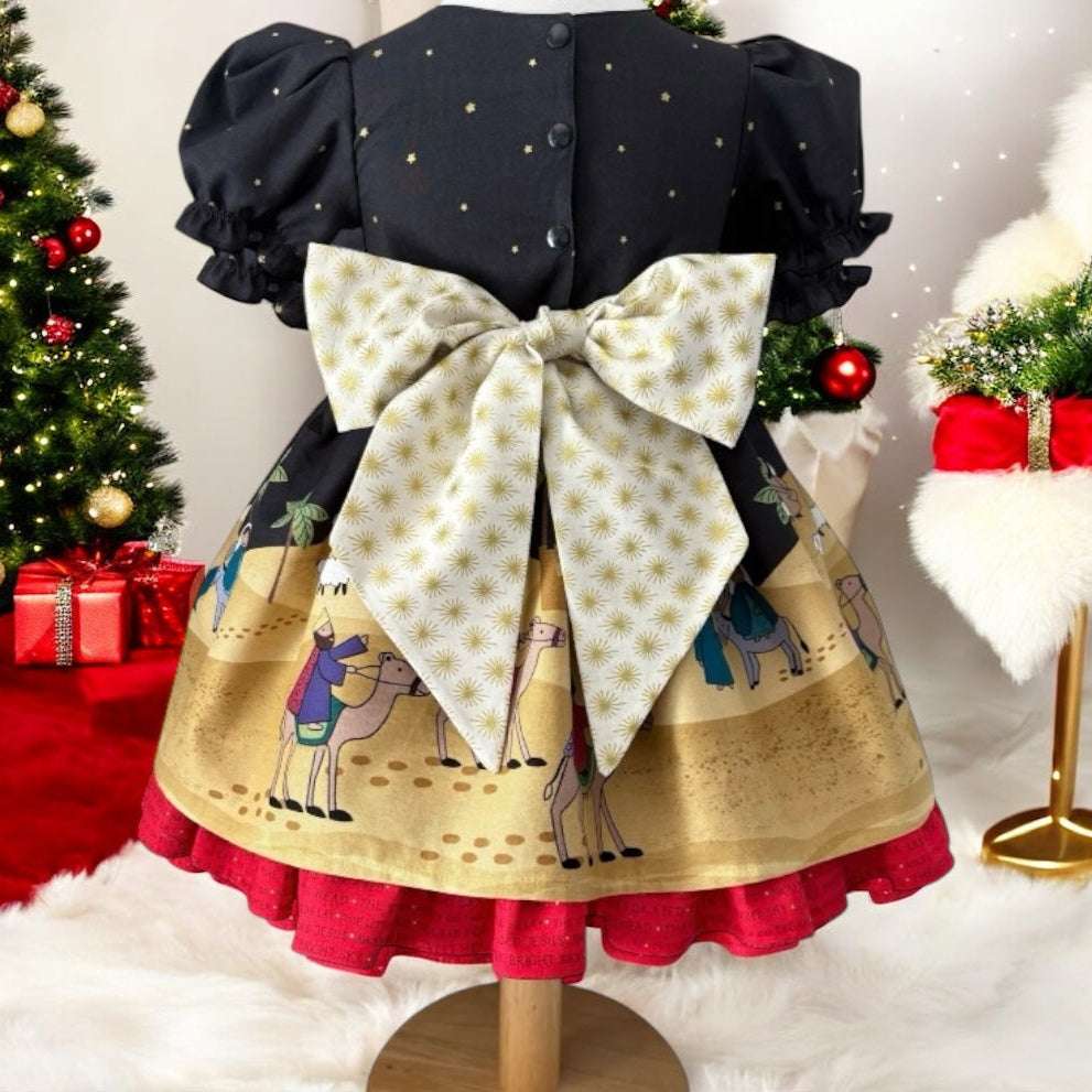 Christmas-themed dress on a mannequin with a decorated Christmas tree in the background