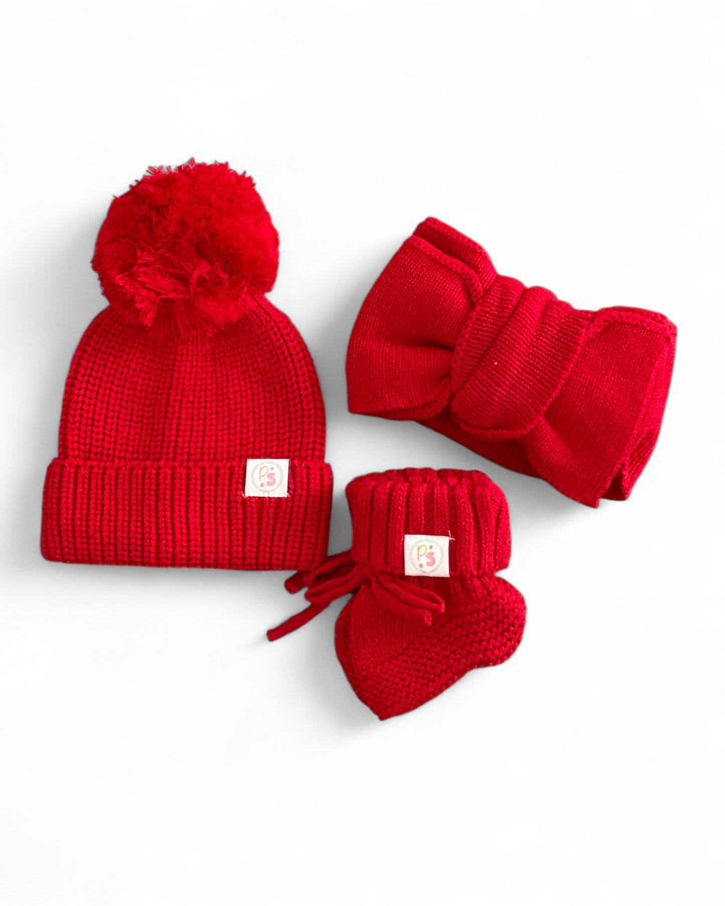 Red knit baby hat with pom-pom, matching headband, and booties