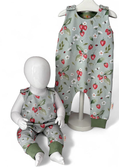 Children's strawberry print romper with floral patterns on a pale green  background