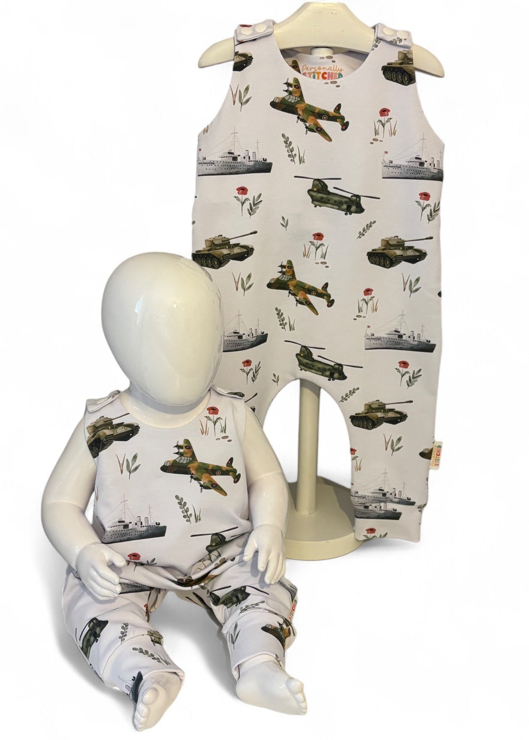 Children's romper with airplane pattern on a mannequin and hanger against a white background