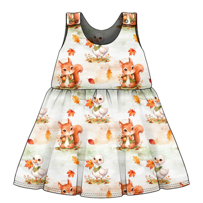 Children's dress with autumn-themed design featuring squirrels and birds on a white background