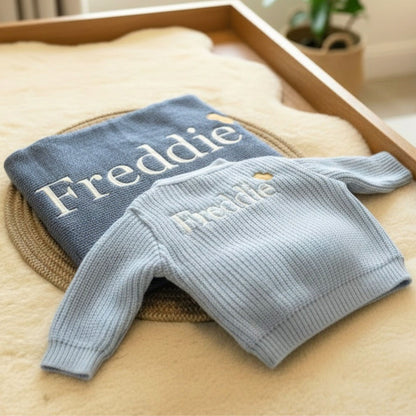 A personalised ribbed knit cardigan and matching blanket with the name 'Freddie' embroidered on them. 