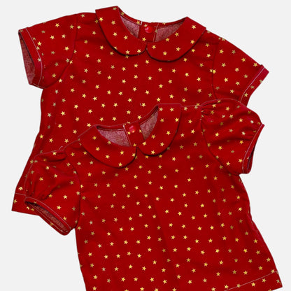 Two red short-sleeve tops with a gold star pattern and Peter Pan collars, displayed on a light gray background.