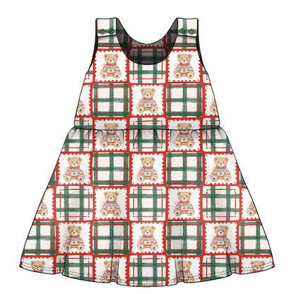 A sleeveless children's dress with a festive holiday pattern of teddy bears with green and red check frames on a white background. age 3 months to 6 years 