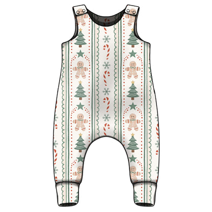 A sleeveless baby romper with an all-over Christmas holiday print featuring gingerbread men, Christmas trees, candy canes, and snowflakes on a cream background with black trim.