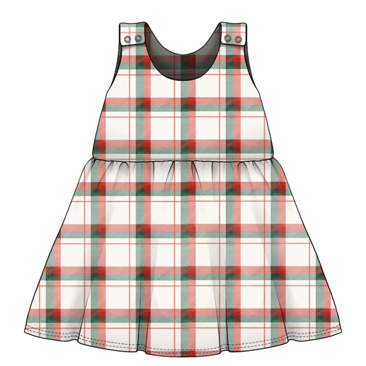 A sleeveless plaid children's dress. The dress has a white base with red and green tartan lines, a gathered waist seam, and small decorative poppers at the shoulder straps.