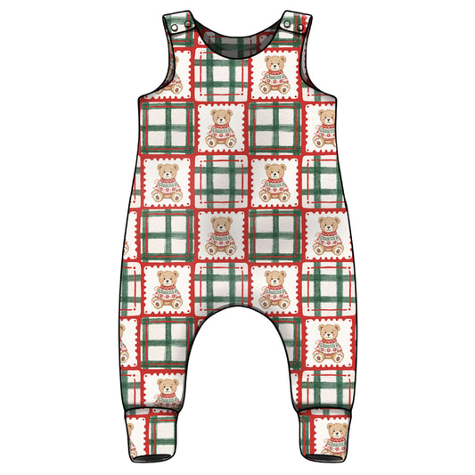 A sleeveless baby jumpsuit with an all-over Christmas-themed pattern featuring green and red plaid squares, scalloped borders, and teddy bears, shown on a plain white background.