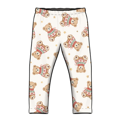 White children's leggings with an all-over print of teddy bears wearing red and green sweaters, accented with small gold stars and black side piping.