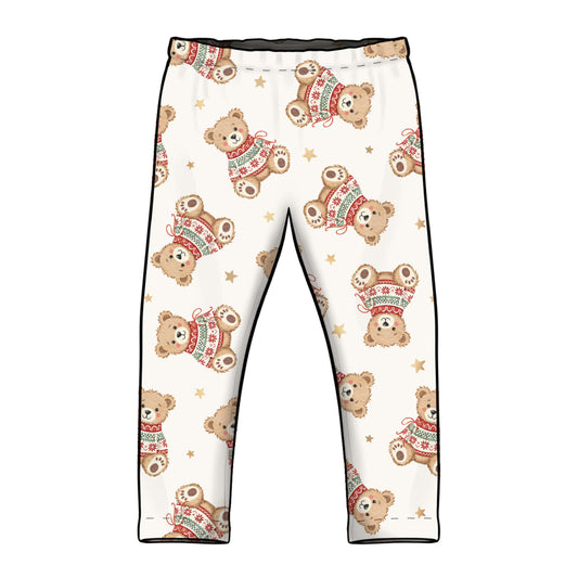 White children's leggings with an all-over print of teddy bears wearing red and green sweaters, accented with small gold stars and black side piping.