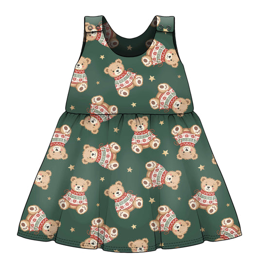 A sleeveless baby dress with a festive holiday print featuring teddy bears wearing red and green sweaters and small gold stars on a dark green base French Terry fabric..