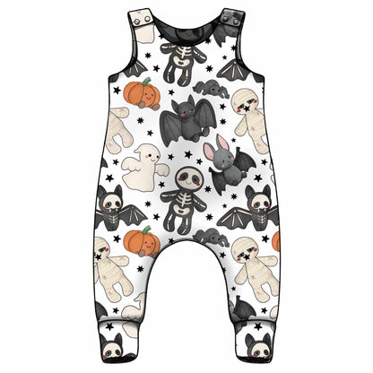 A sleeveless baby romper with a white background and a Halloween-themed cartoon print featuring bats, skeletons, ghosts, pumpkins, and teddy bears.