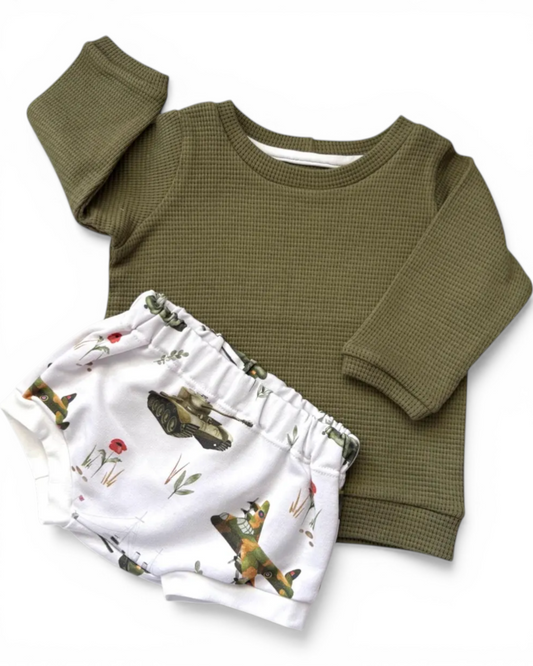 Personally Stitched army green waffle knit baby jumper with white shorts featuring vintage military print. Soft cotton blend.