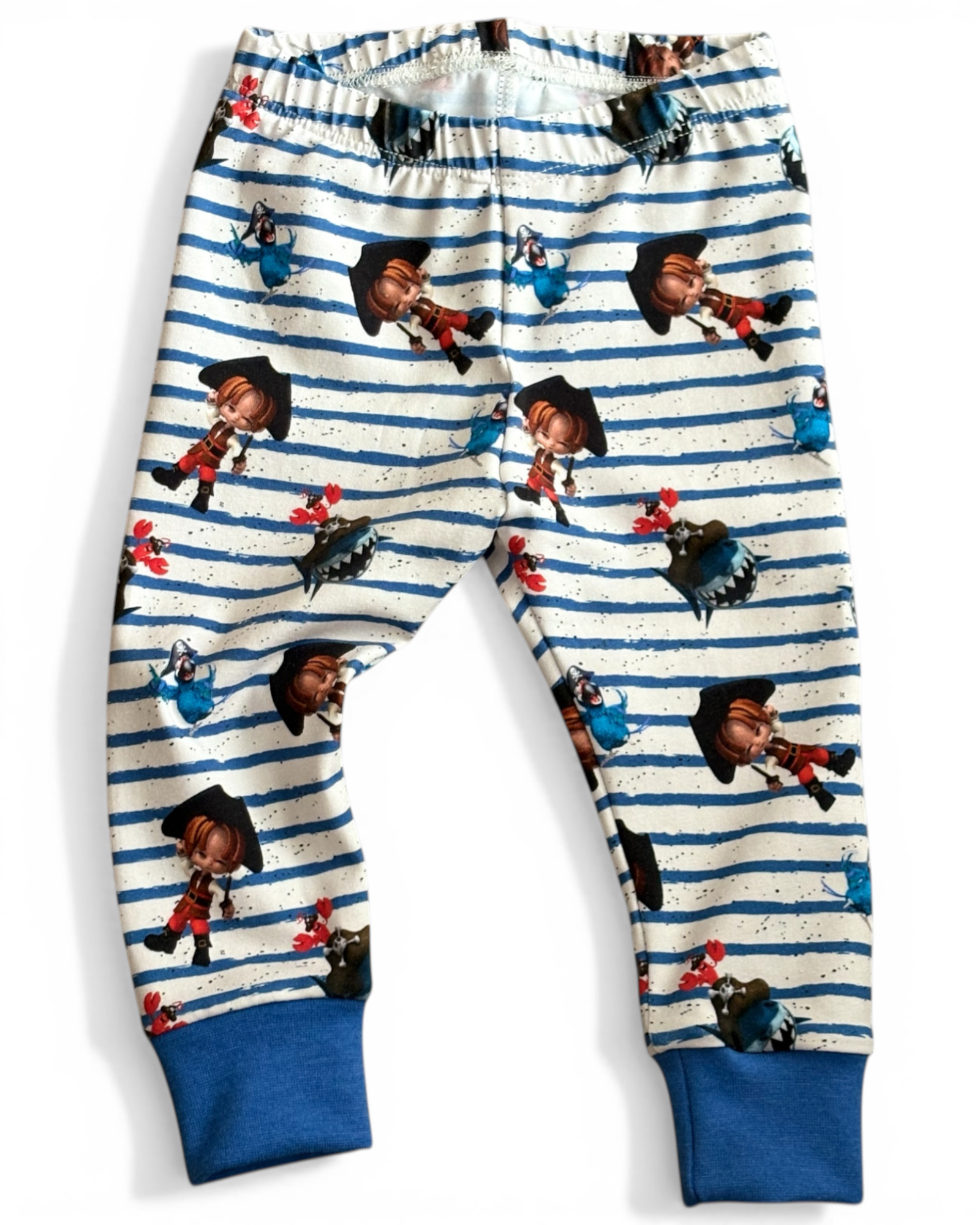 Personally Stitched 6-9 month baby leggings with blue and white stripes and a pirate print, featuring blue cuffs. Made from organic jersey.