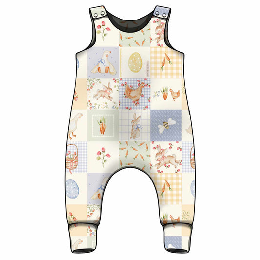Children's romper with a patchwork quilt spring design featuring animals and nature with matching print for the ankle cuffs