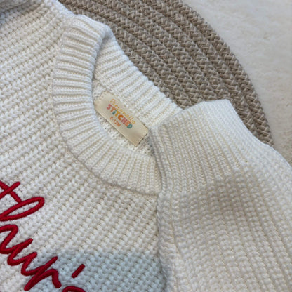 Close-up of a neck label by Personally Stitched on a white-coloured knit romper with red script embroidery on the chest.