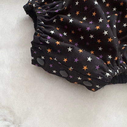 popper closure on a baby cotton woven romper for ease of nappy changing 