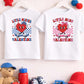 Valentine’s kids T-shirts displayed on wooden rail with red and blue accessories